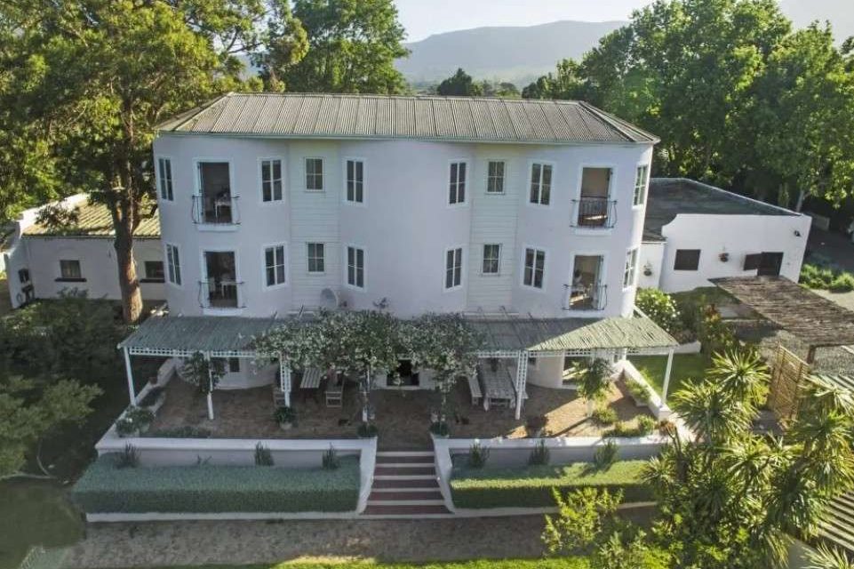 Elegant front view of French Country Silo Villa in Cape Town surrounded by greenery and blue skies.