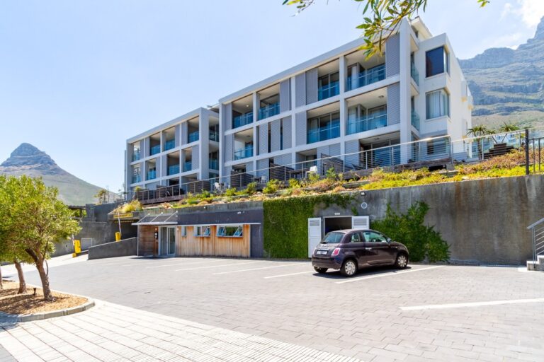 Modern apartment building exterior with mountain backdrop and secure parking at 312 The Crystal