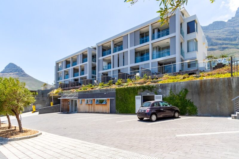Modern apartment building exterior with mountain backdrop and secure parking at 312 The Crystal