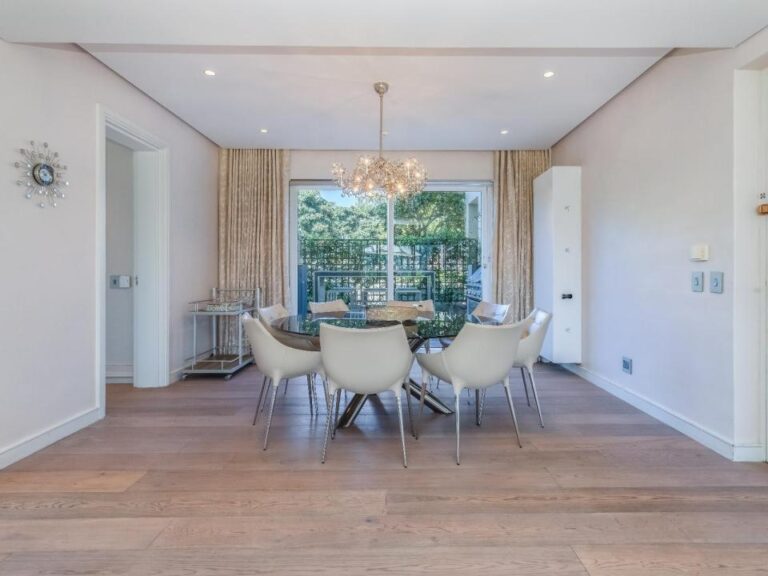 Sophisticated dining area with designer chandelier and balcony access at Ellesmere 301