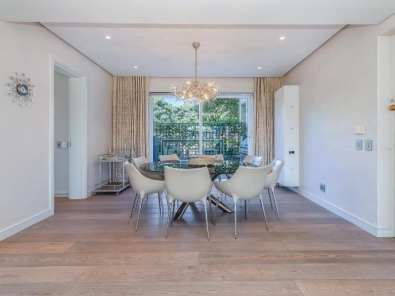 Sophisticated dining area with designer chandelier and balcony access at Ellesmere 301