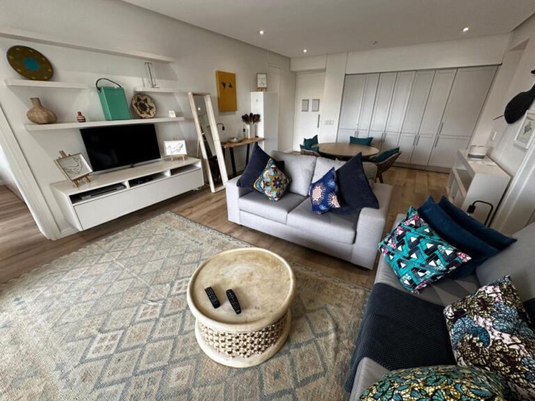 Inviting lounge with vibrant cushions and smart TV setup at Altmore 103