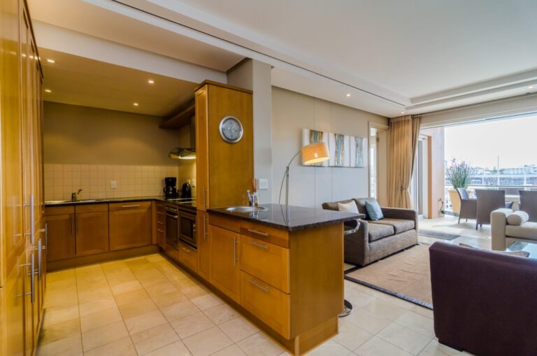 Open-plan kitchen and lounge with warm wooden finishes at Parama 302