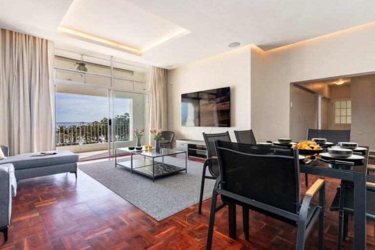 Elegant open-plan living and dining area with sea views at Caprice Bay