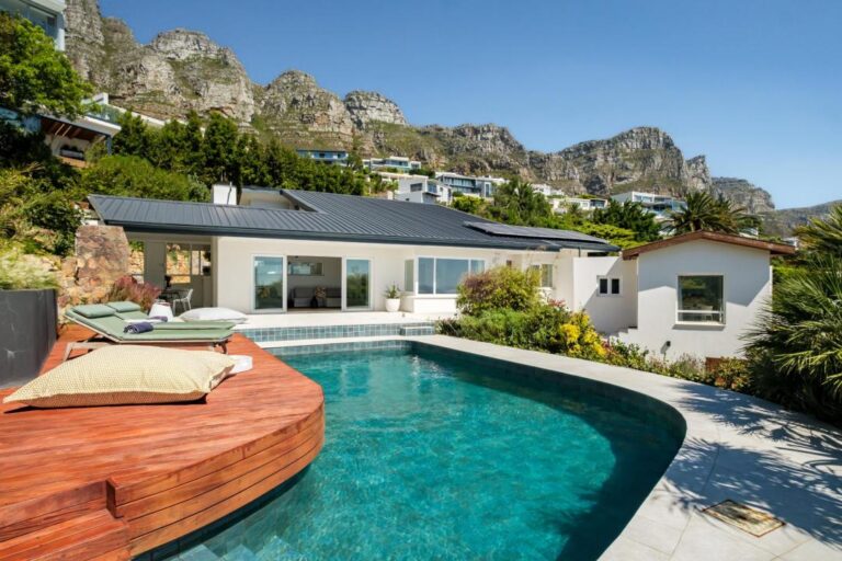 Curved swimming pool with mountain views and lush garden deck at Aqua Terra