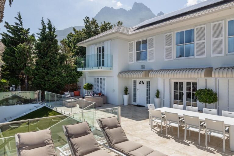 Elegant villa exterior with sun loungers outdoor dining and mountain views Villa Galazzio