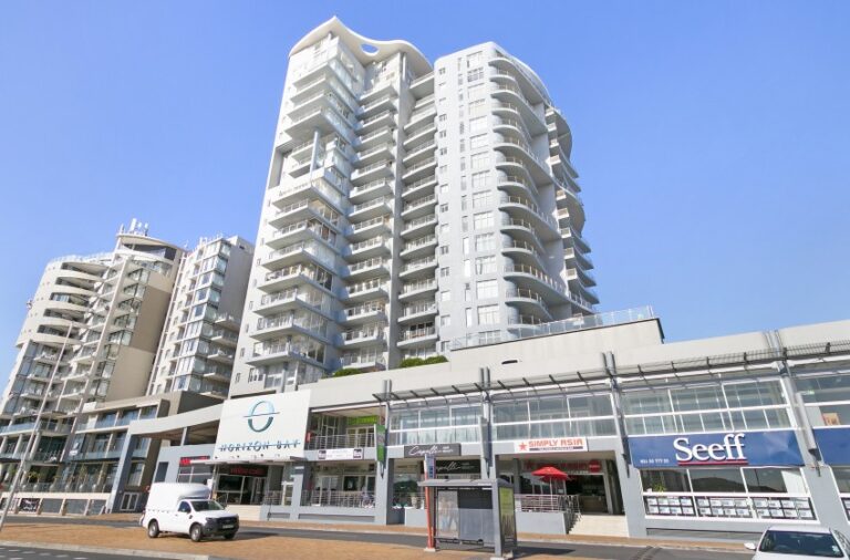Modern beachfront apartment building exterior with retail spaces at Horizon Bay 201