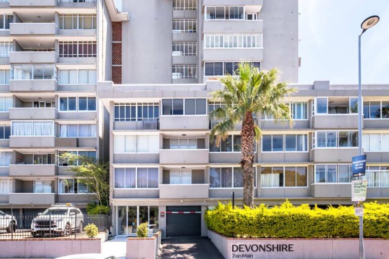 Contemporary apartment building exterior with palm tree at Aquene Bay