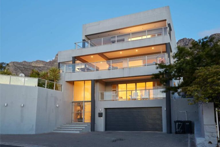 Modern multi-level villa exterior with expansive balconies and mountain backdrop at Apostles View