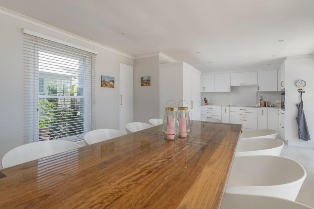 Bright open plan dining area with large wooden table and modern kitchen Villa Galazzio