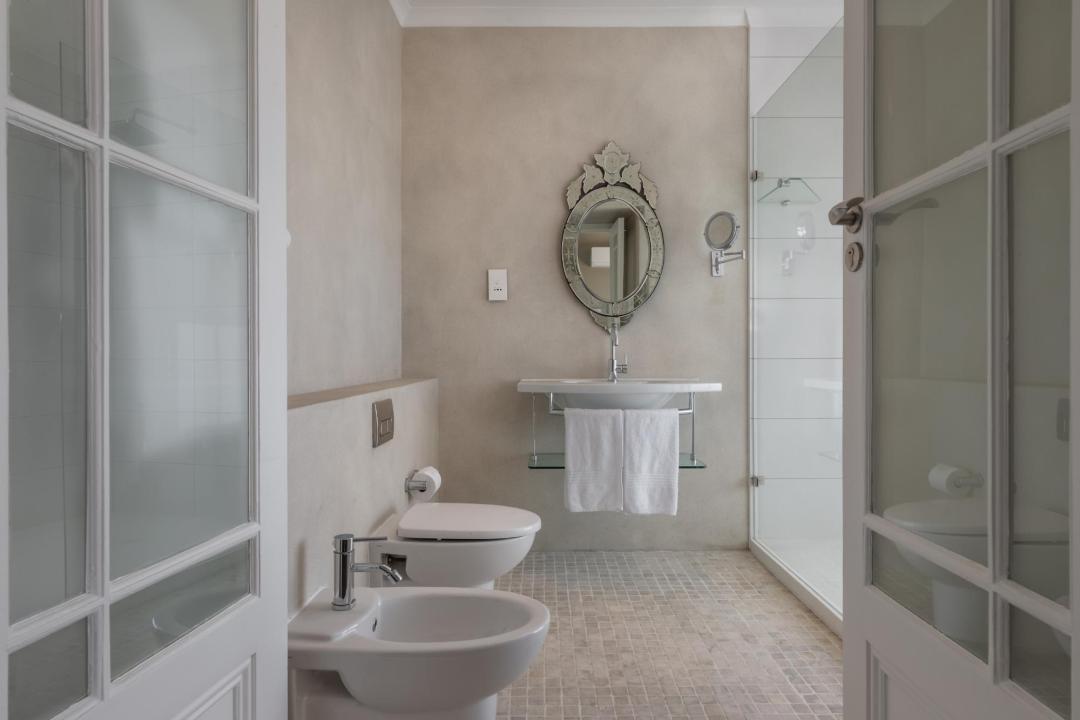 Elegant bathroom with glass shower vintage mirror and neutral tones Villa Galazzio