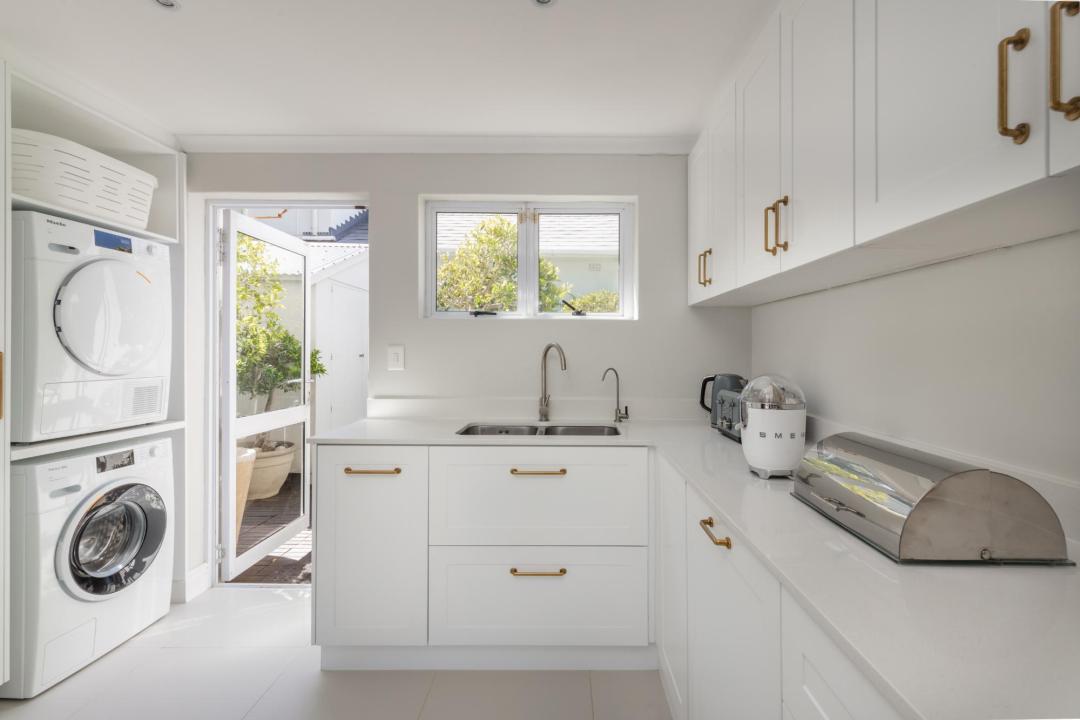 Modern white laundry and utility room with garden access Villa Galazzio