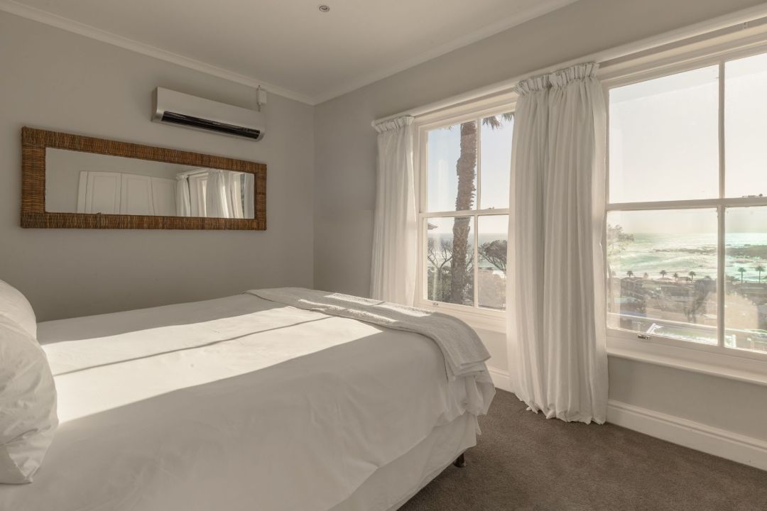 Serene bedroom with ocean views large window and white bedding Villa Galazzio