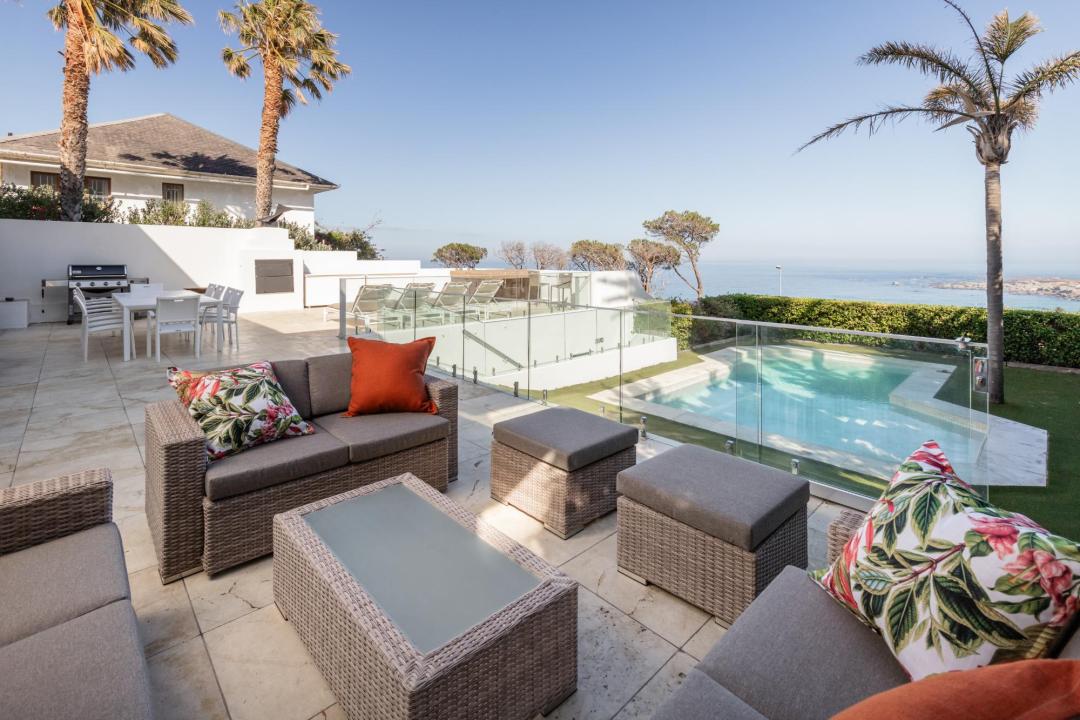 Spacious outdoor lounge area with pool ocean views and palm trees Villa Galazzio