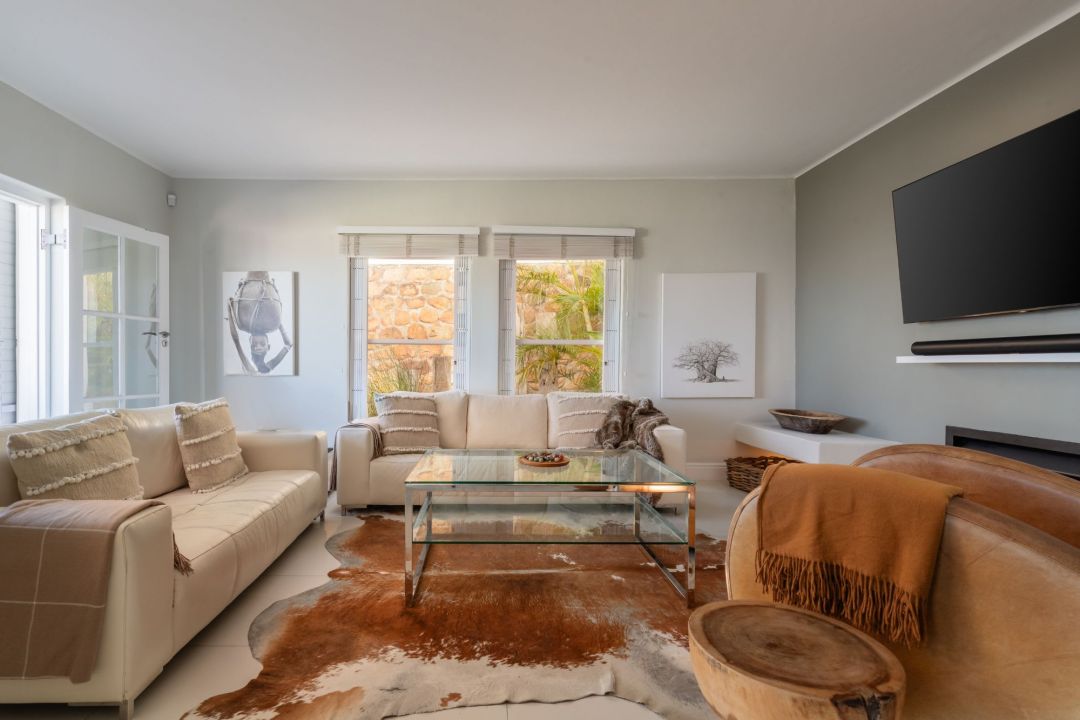 Stylish contemporary living room with neutral tones cowhide rug and wall art Villa Galazzio