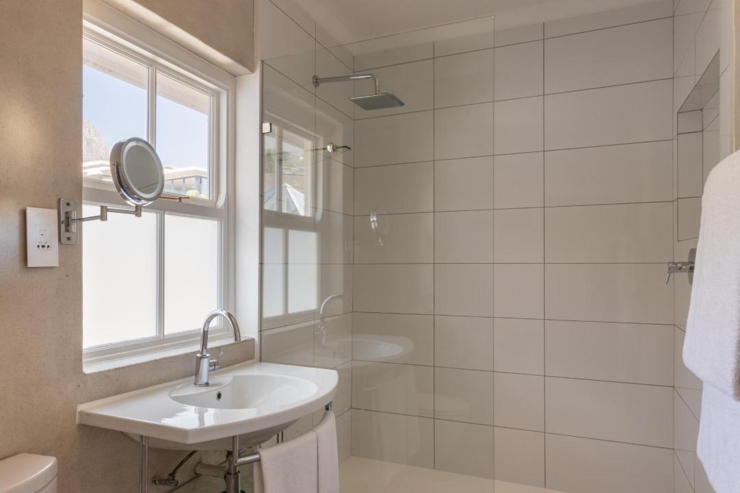 Bright minimalist bathroom with walk in shower and large window Villa Galazzio