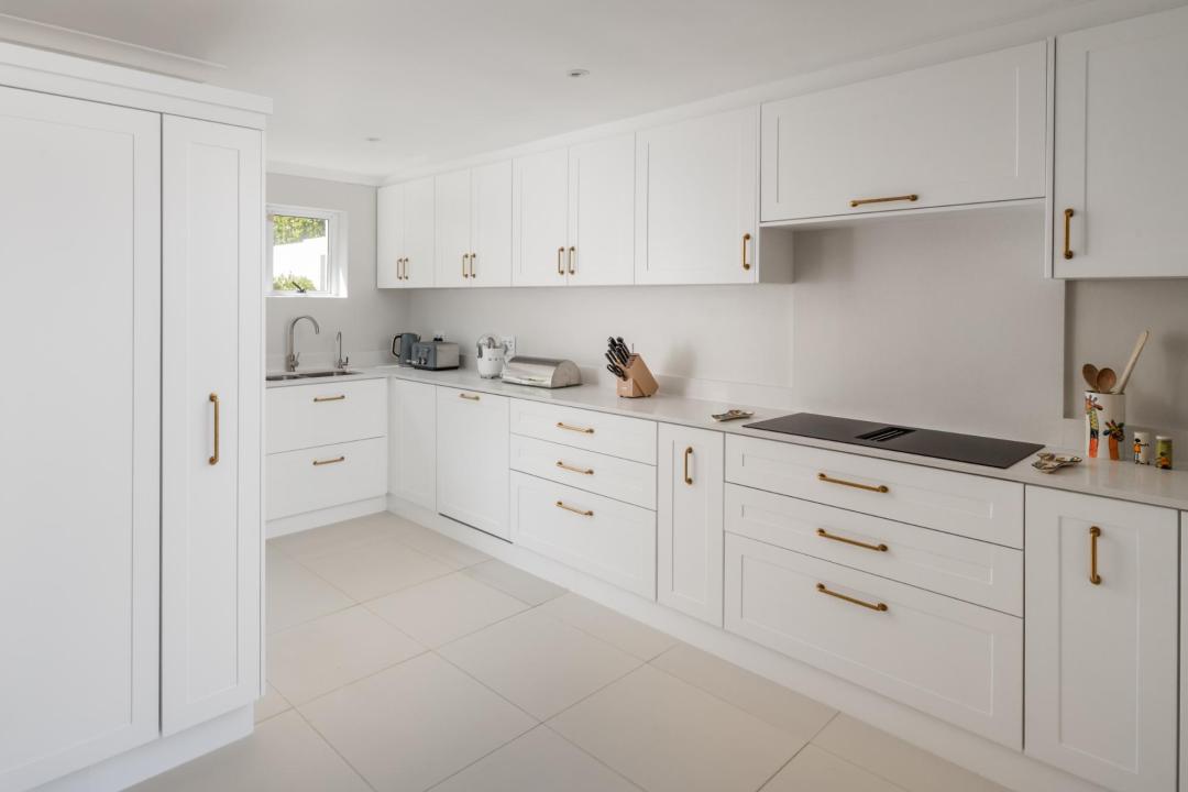 Modern all white kitchen with sleek finishes and gold handles Villa Galazzio
