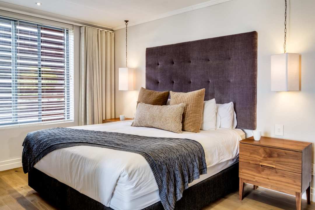 Sophisticated bedroom with tufted headboard and pendant lighting at Aureto