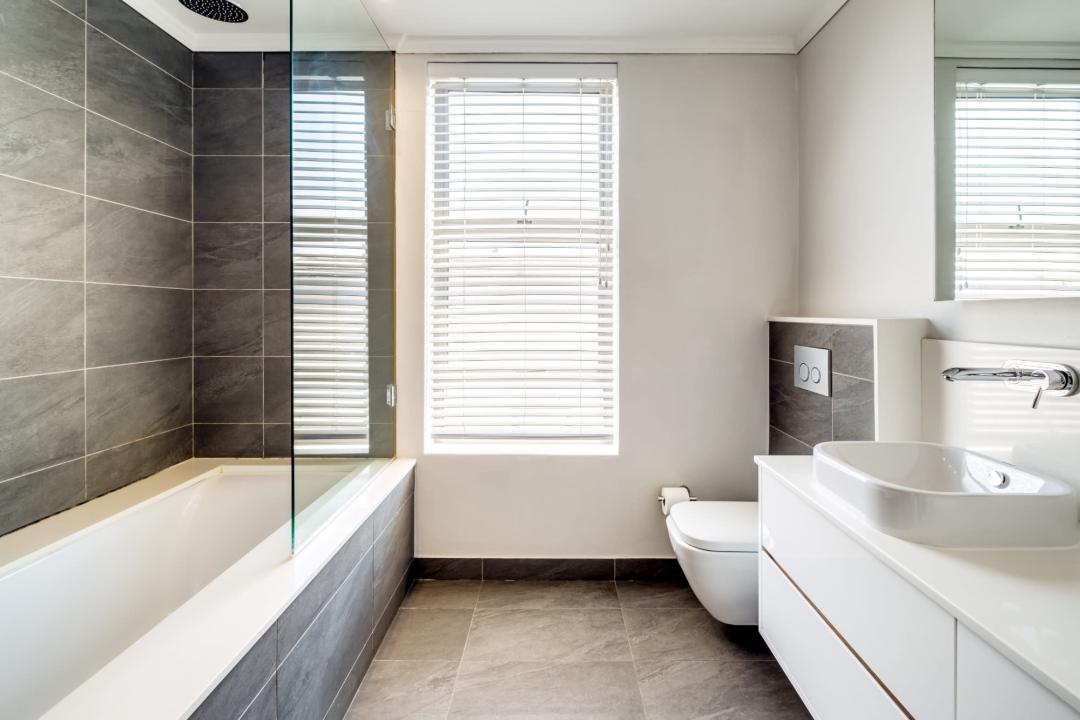 Chic bathroom with deep bathtub and natural light at Aureto