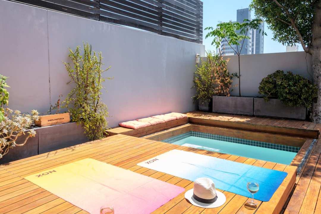 Private plunge pool with sunny deck and vibrant lounging space at Aureto