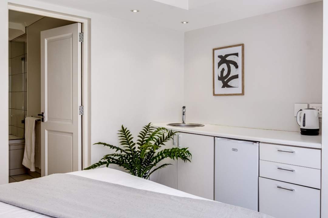 Compact kitchenette with modern finishes and greenery at Aureto