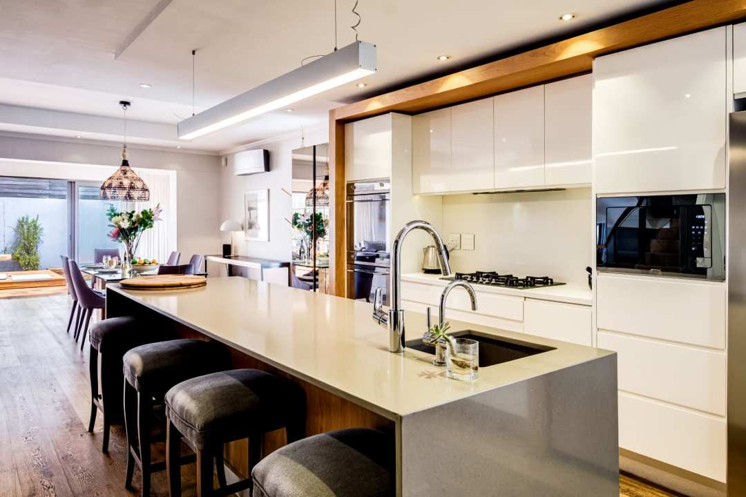 Sleek open-plan kitchen with central island and designer lighting at Aureto