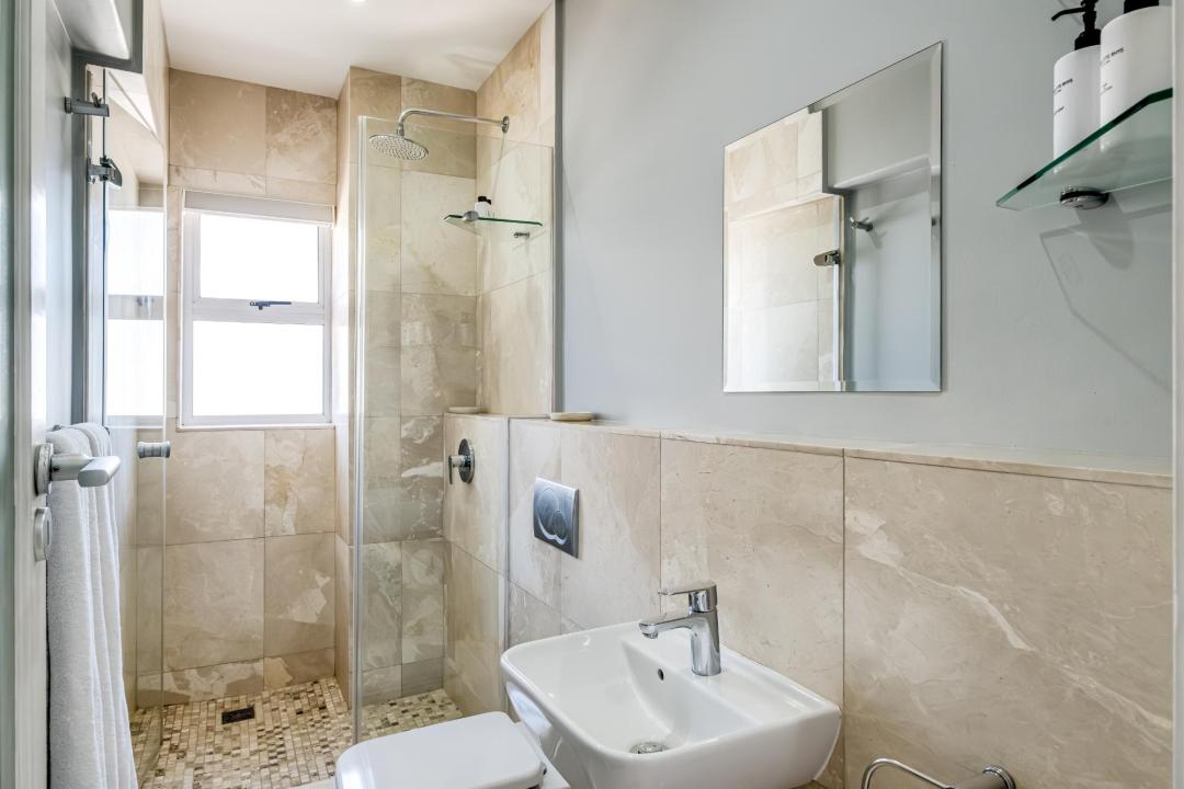 Contemporary bathroom with walk-in shower and natural stone tiles at Atlantic Views