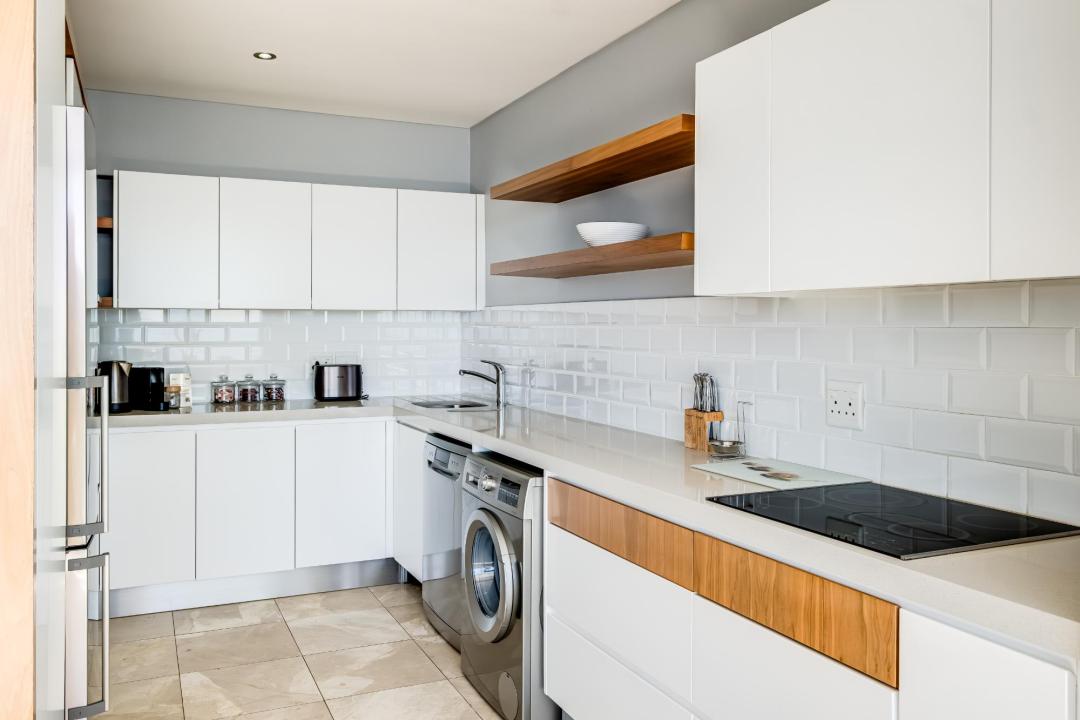 Modern white galley kitchen with subway tiles at Atlantic Views