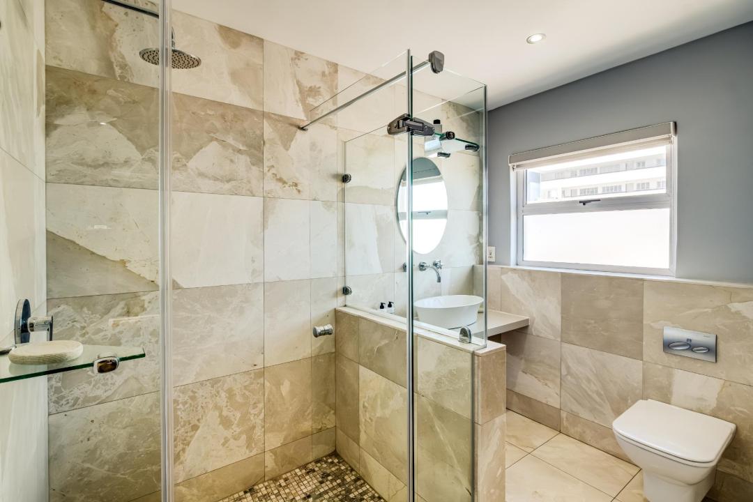 Spacious bathroom with walk-in rainfall shower and stone finishes at Atlantic Views