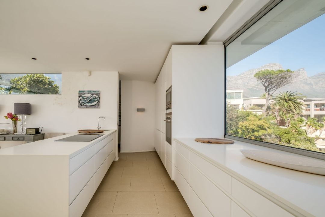 Minimalist kitchen with mountain views and sleek white cabinetry at Silvertree
