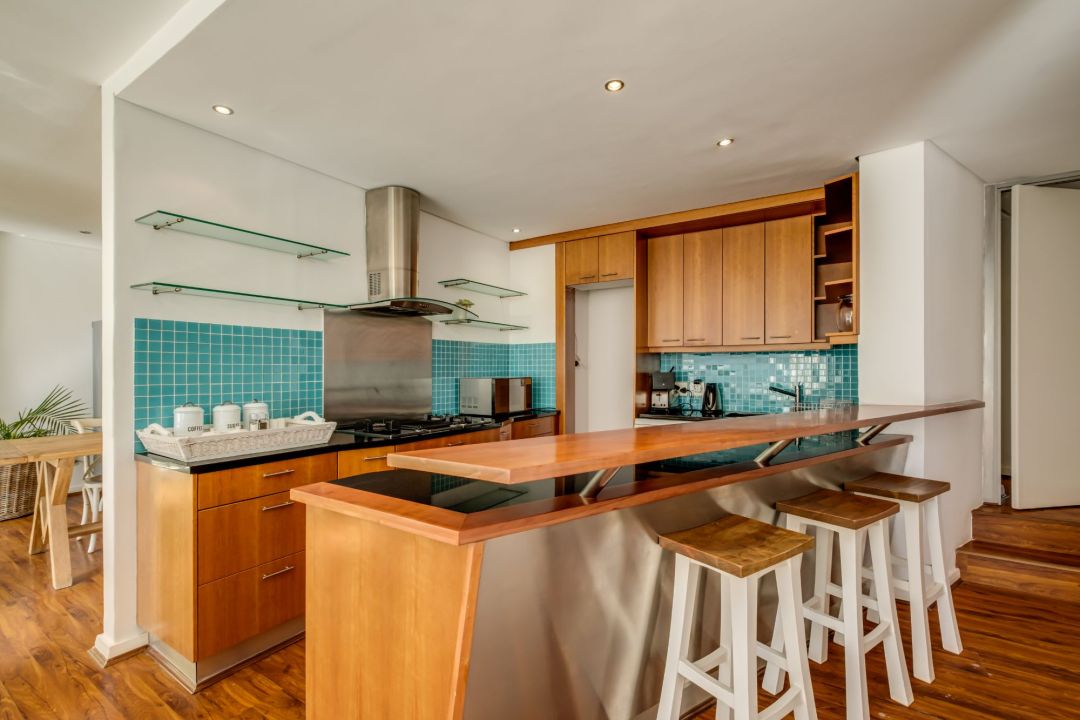 Warm-toned kitchen with turquoise backsplash and breakfast bar seating at Silvertree