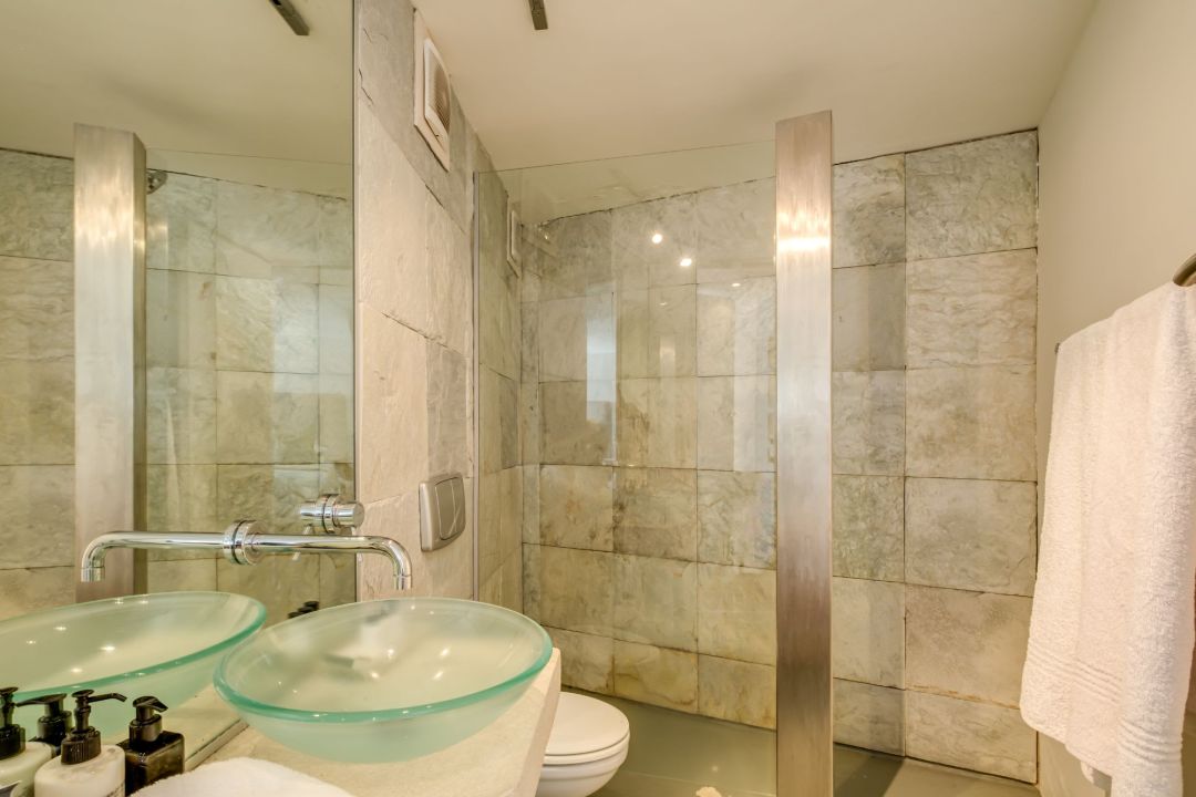 Contemporary bathroom with stone-tiled shower and glass basin at Silvertree