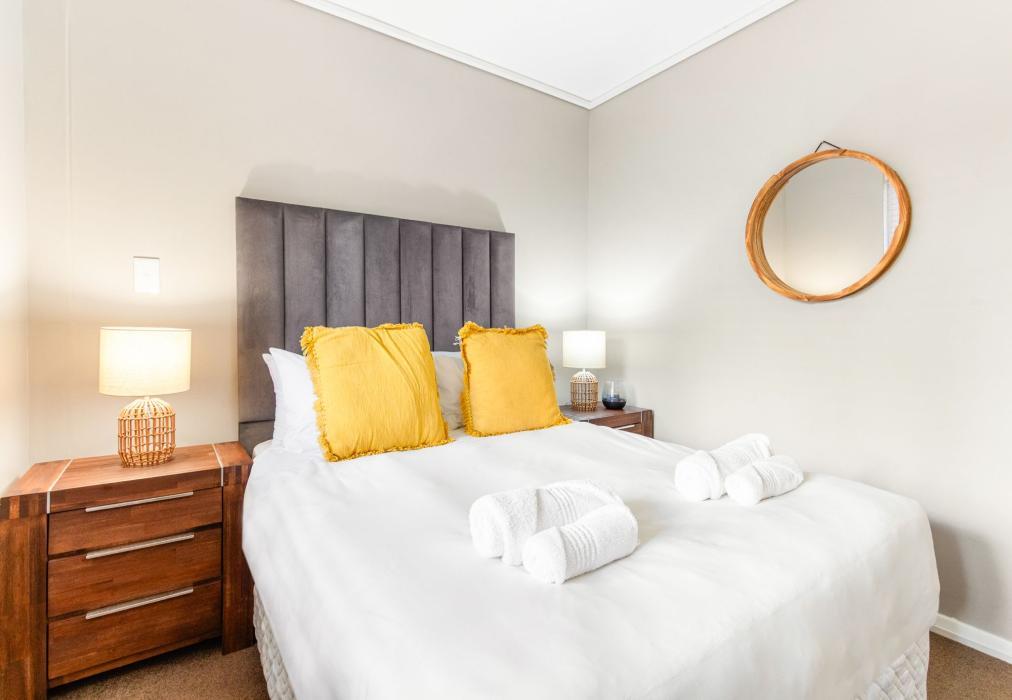 Second Bedroom with Plush Headboard and Warm Accent Lighting at Lagoon Beach 29A