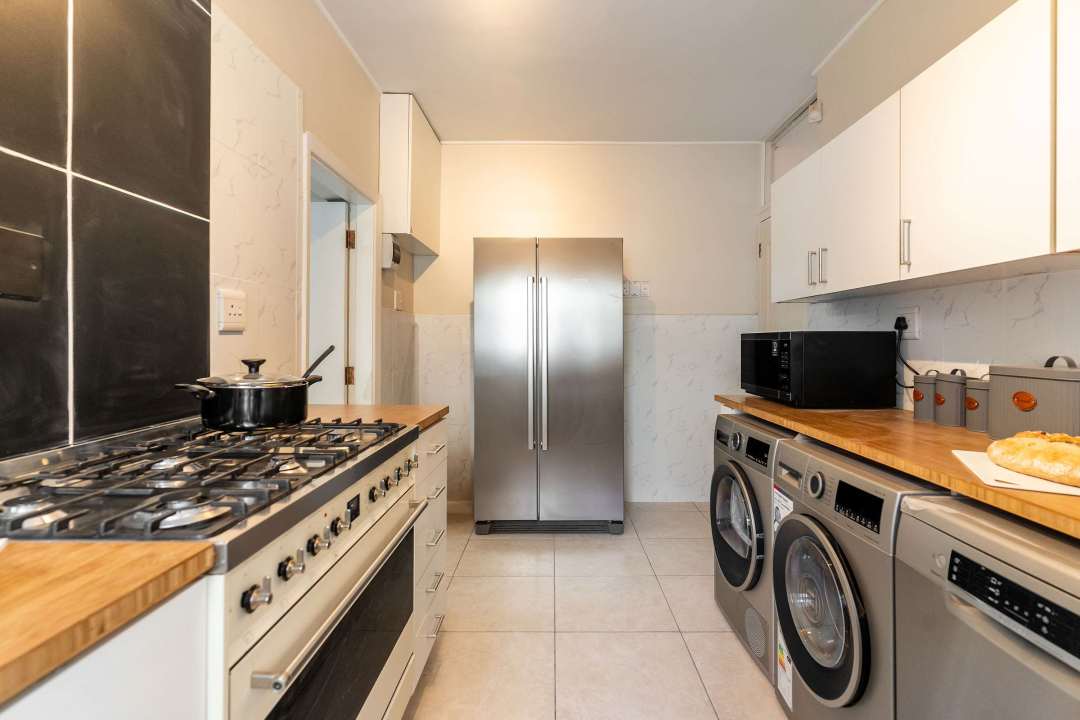 Fully equipped kitchen with gas stove and laundry appliances at Caprice Bay