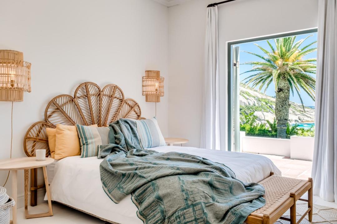 Bright coastal bedroom with palm-lined terrace at Solmara
