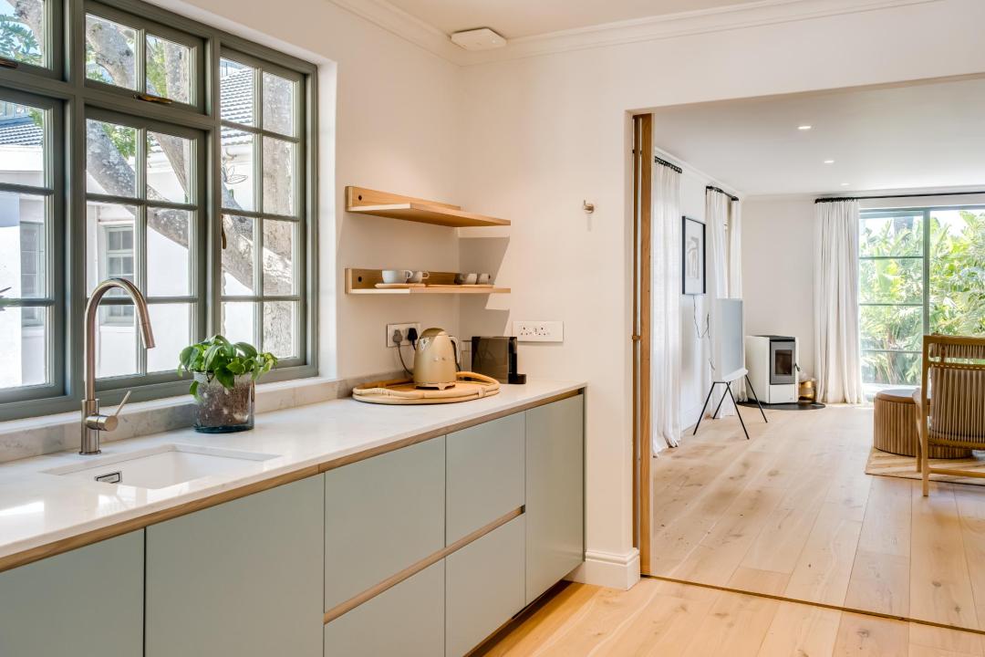 Minimalist kitchenette with natural light and oak floors at Solmara