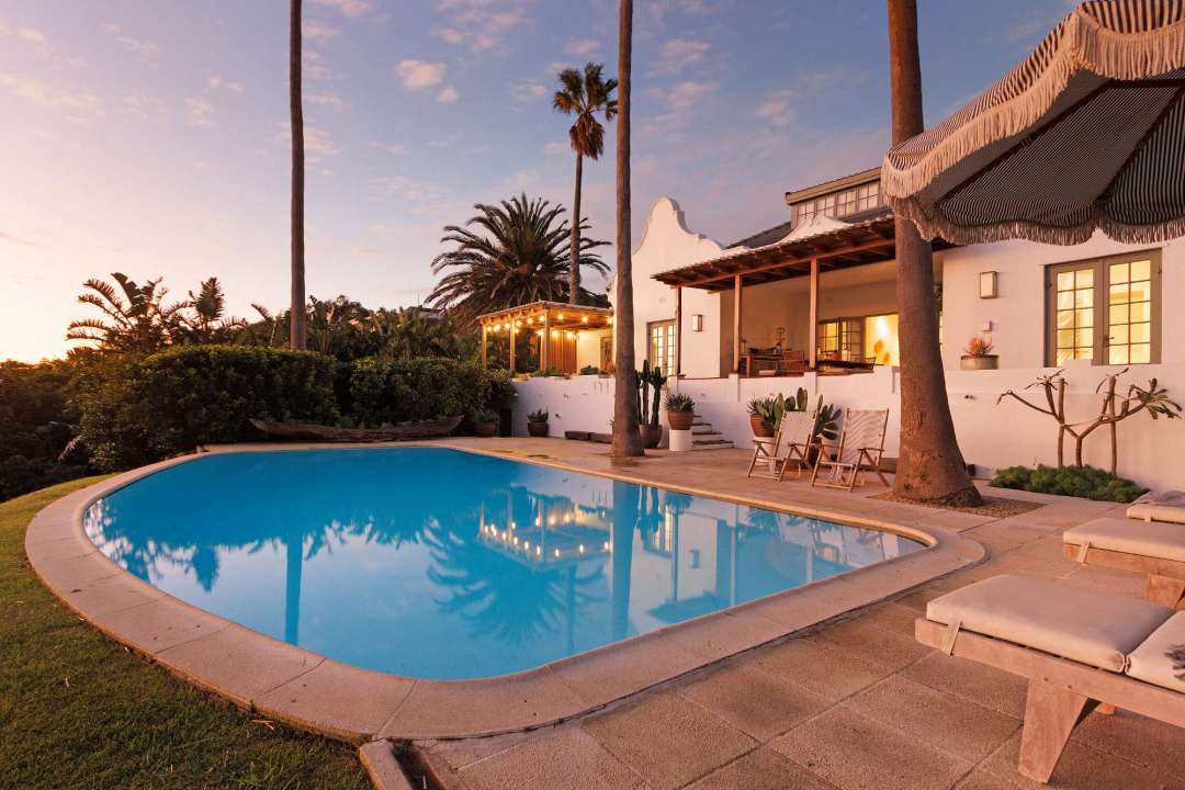 Tranquil sunset poolside retreat with lush palms at Solmara