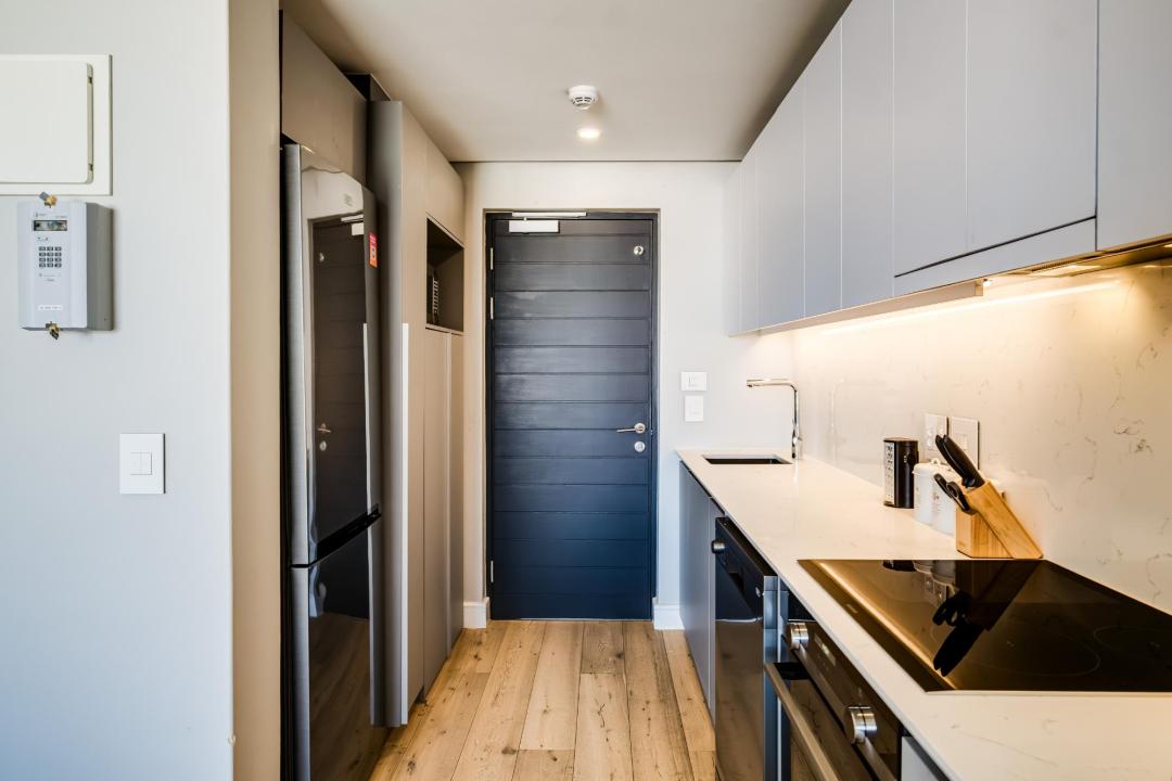 Sleek modern galley kitchen with wood flooring at Bantry Pad