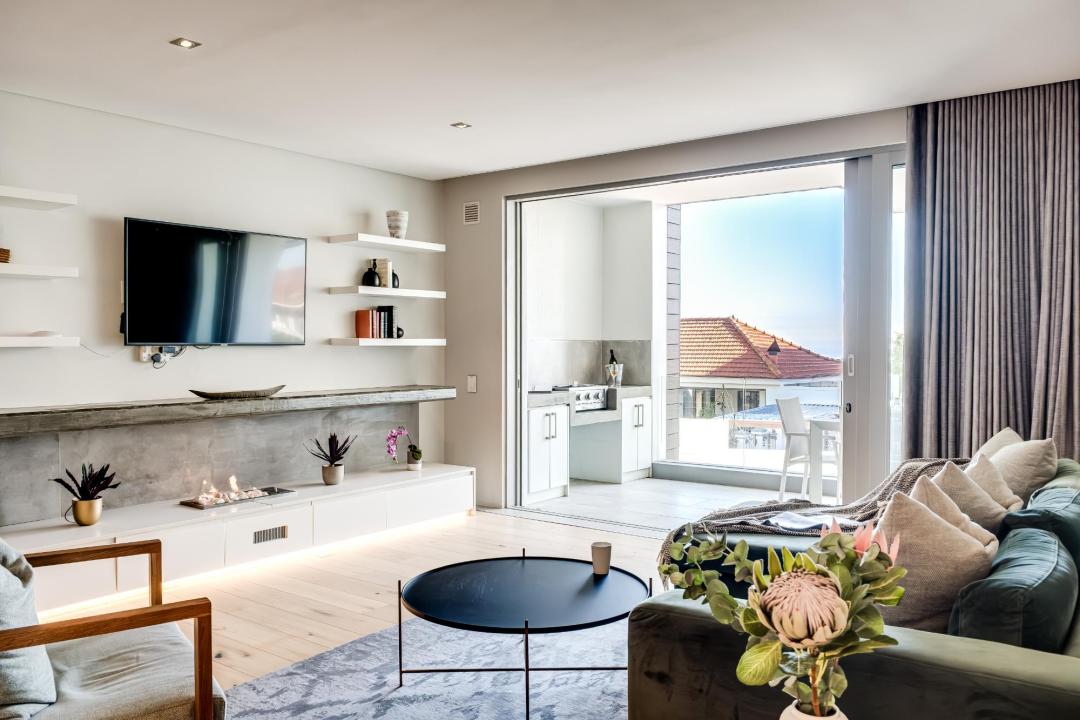 Elegant Open-Plan Living Room with Balcony Access and Modern Fireplace at Nobelium