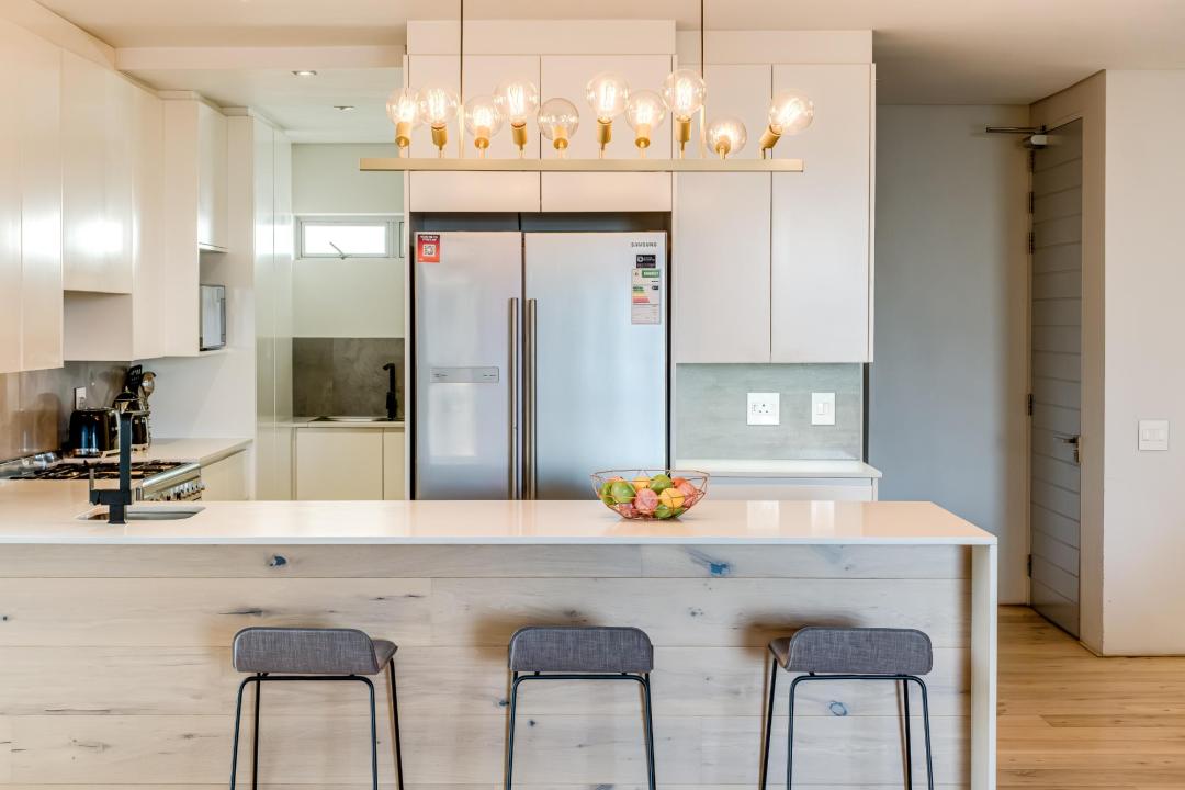 Modern Gourmet Kitchen with Island Seating and Designer Lighting at Nobelium